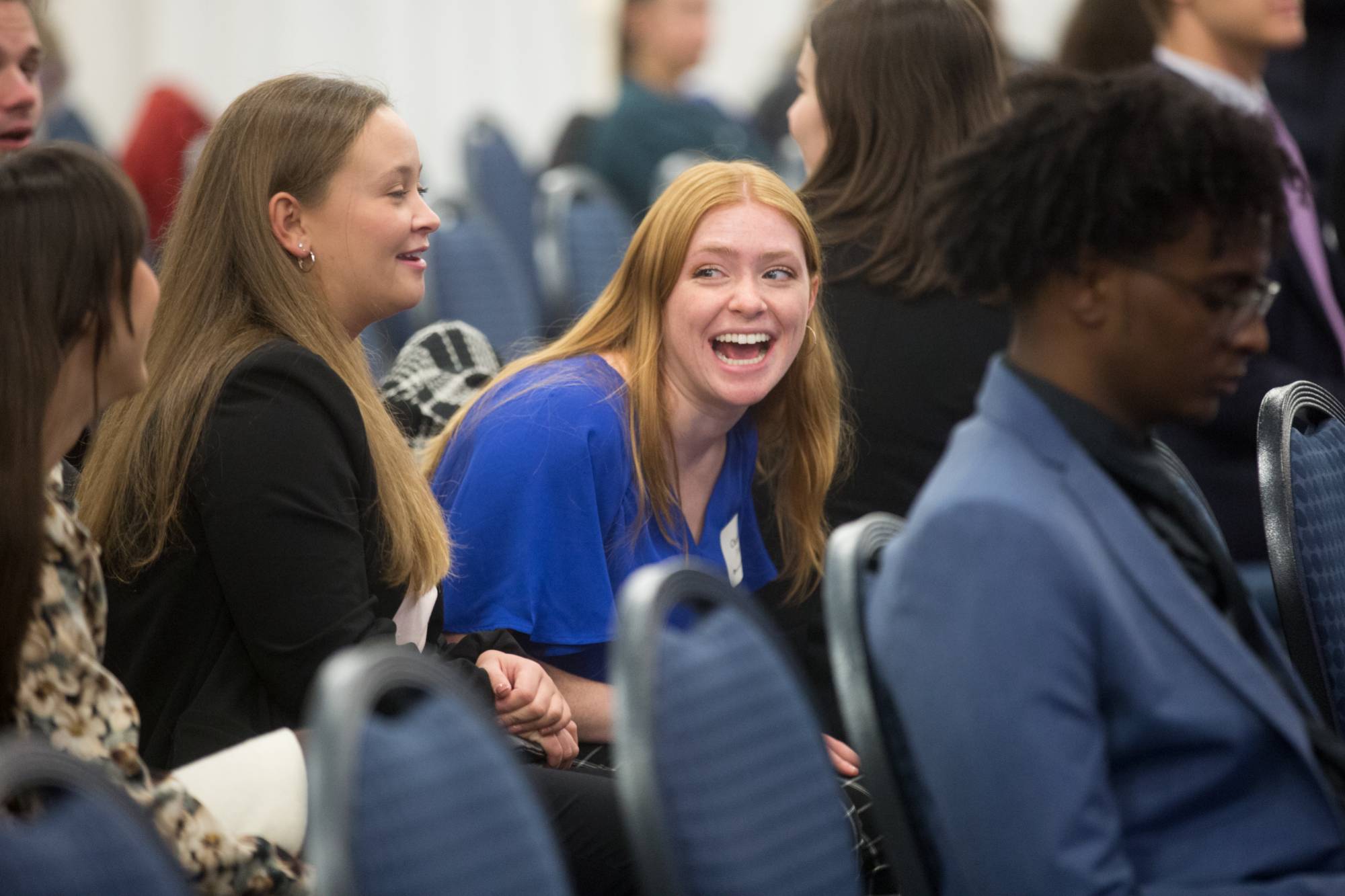 students laughing in audience at event